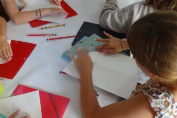 Des enfants font des pliages lors d'un atelier au musée.