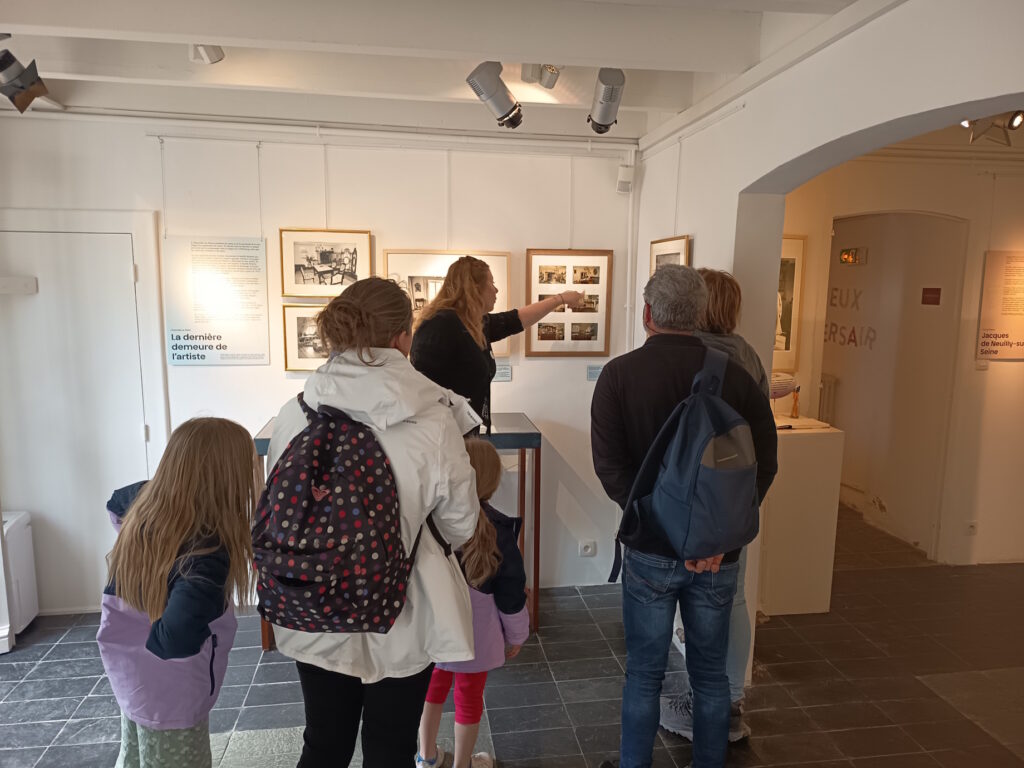 Une médiatrice présente des photographies dans l'exposition lors de la visite guidée.