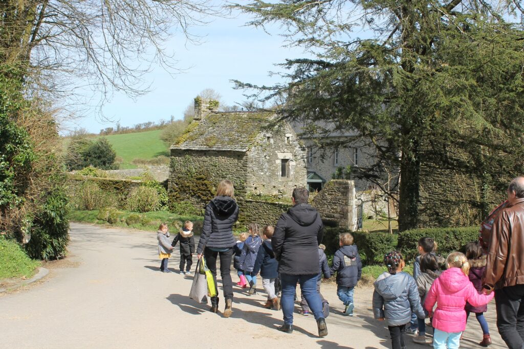 Des enfants se promènent sur la route, devant la maison Jacques Prévert