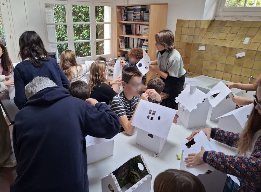 Les collégiens assemblent leur maquette avant de les disposer dans l'atelier.