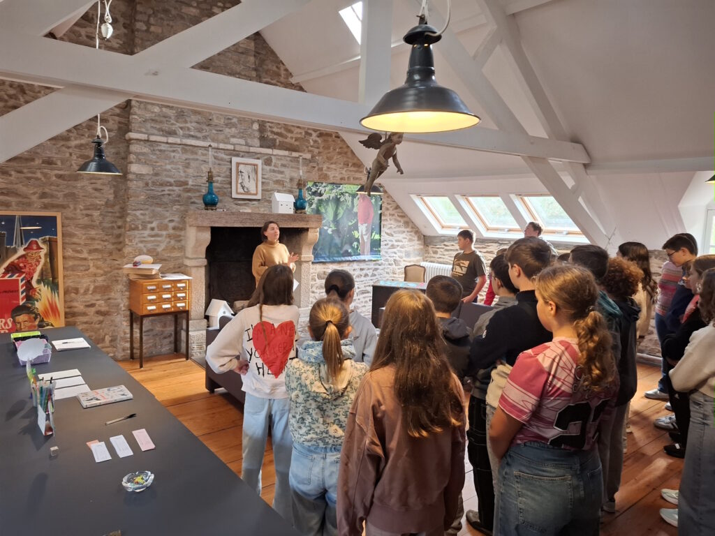 Dans l'atelier, la médiatrice présente le projet et son organisation aux élèves.