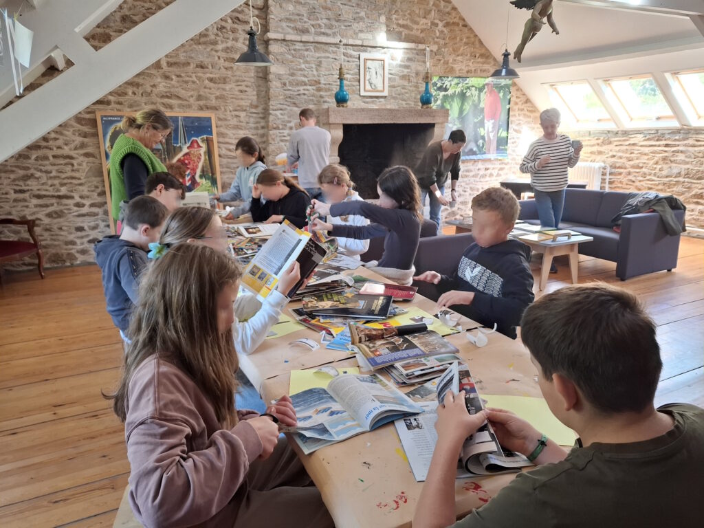 Les élèves font du collage sur une grande table dans l'atelier du musée.