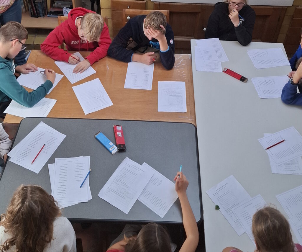 Vue du dessus, les élèves participent à un atelier d'écriture dans la cuisine de la maison.