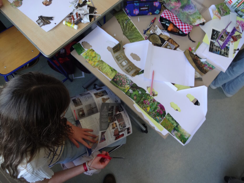 Une élève cherche des images dans un magazine pour compléter son collage à l'intérieur de sa maquette sur le thème des fleurs.