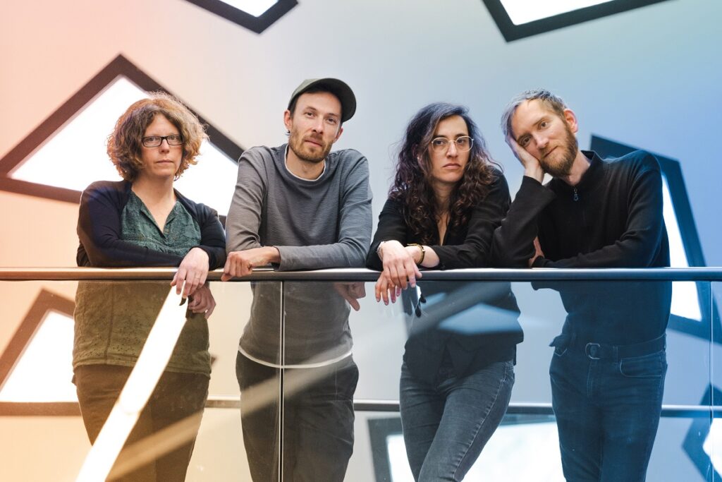 Deux femmes et deux hommes debout constitue le groupe musical Chapelier Fou